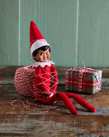 the elf wrapped up in bakers twine next to a wrapped package