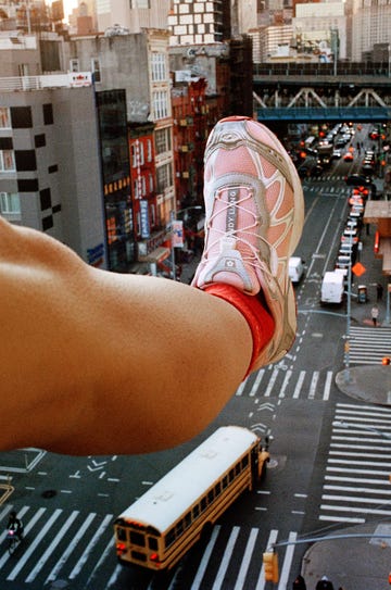 leg dangling over a busy city intersection with a sneaker visible