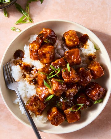 chili crisp fried tofu on rice in a bowl topped with scallions