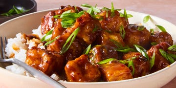 chili crisp fried tofu in a bowl on rice topped with scallions