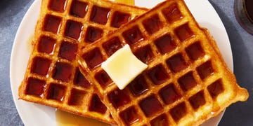 square classic waffles topped with butter and drizzled with maple syrup