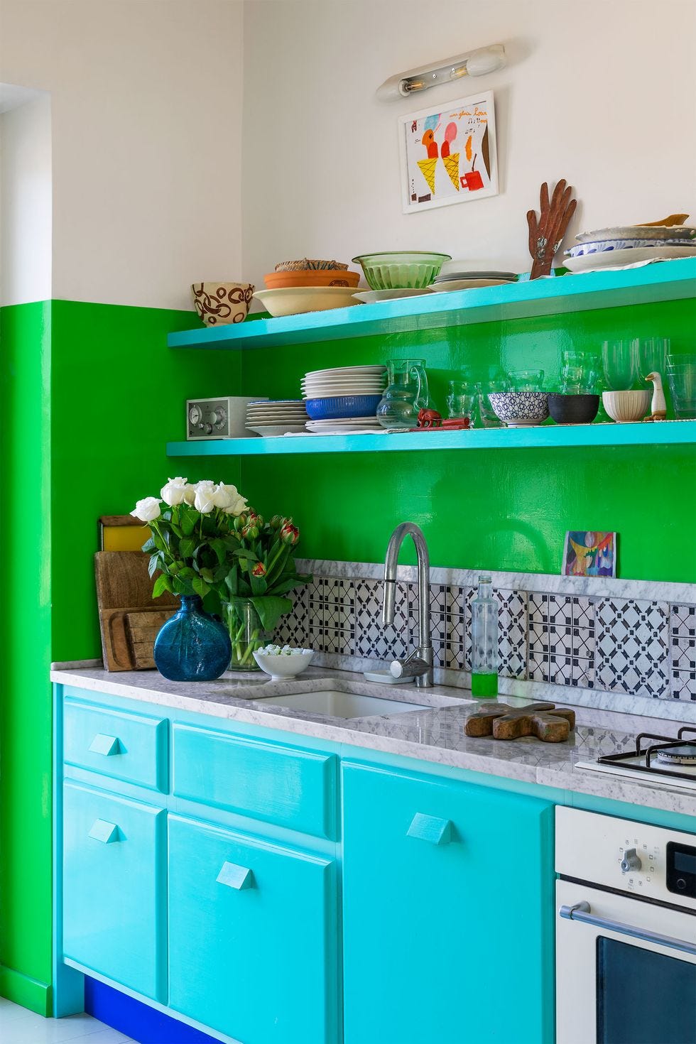 a kitchen with neon blue cabinets and neon green walls, as well as open shelves and a backsplash of sicilian tile