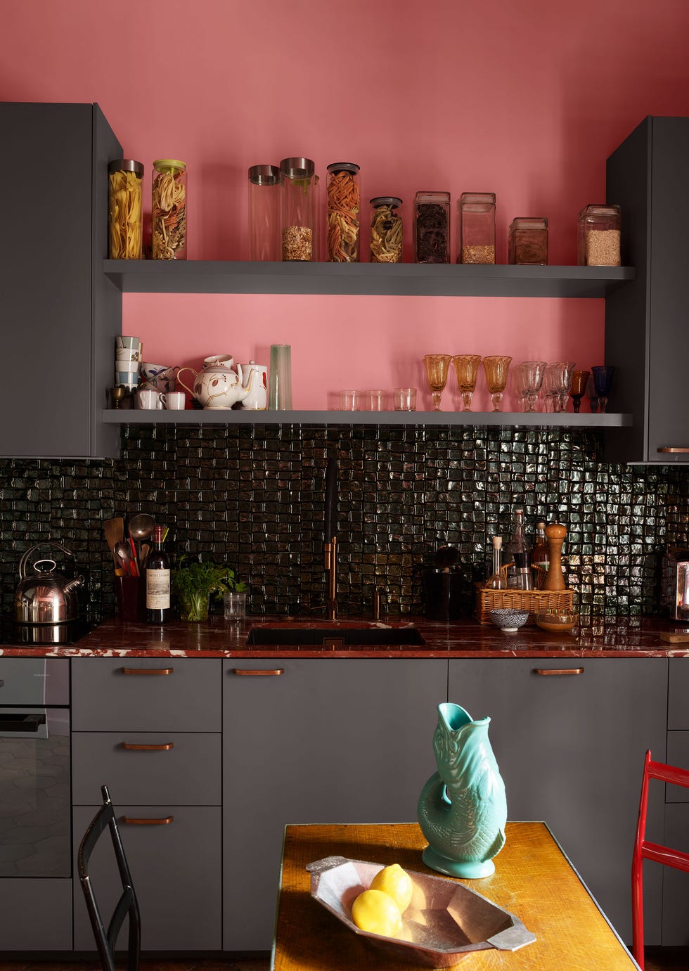 eric allart elle decor project, featuring a kitchen with black ceramic tiles for a backsplash and pops of blue, red, and pink throughout