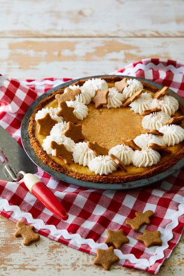 a pie with dolops of cream and little gingerbread people and stars on it