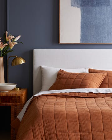 a cozy bedroom setting with a bed adorned in warmtoned bedding