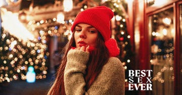 a woman in winter attire standing in a festive environment