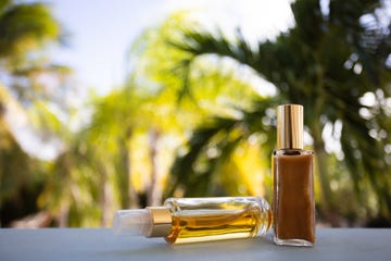 small bottles of cosmetic oils on a palm leaves background