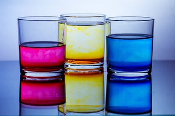 drinking glasses with pink, yellow and blue food dyes