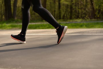 legs of a person running on on a run walking the man is running sportswear healthy lifestyle wet footprints from shoes on the dry surface of the track