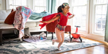 girl playing in superhero cape and butterfly mask