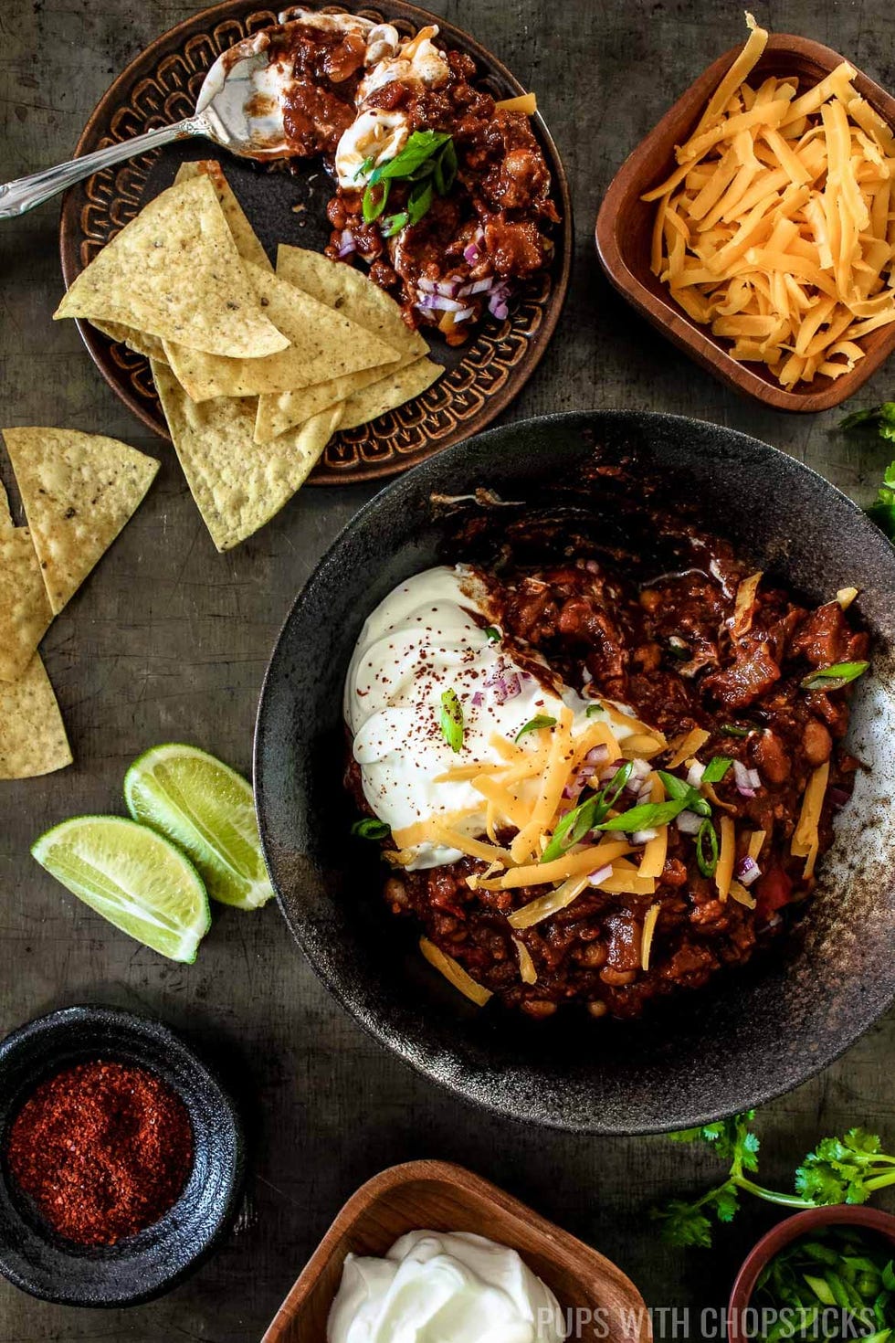 sweet and smoky pineapple chipotle chili with chips, limes and cheese