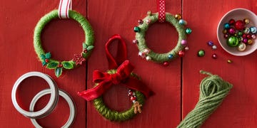 ornaments made from mason jar rings wrapped in twine on a red surface