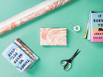 gift wrapped book with marbled wrapping paper, scissors, tape and books