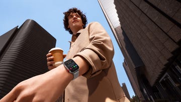 a man wearing a smartwatch, holding a cup of coffee