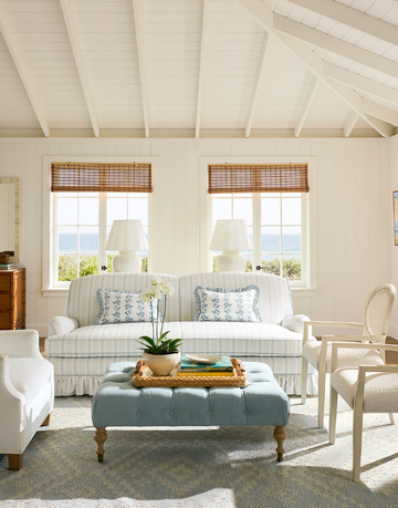 cozy living room with a view of the ocean featuring a twoseater sofa armchairs and a coffee table