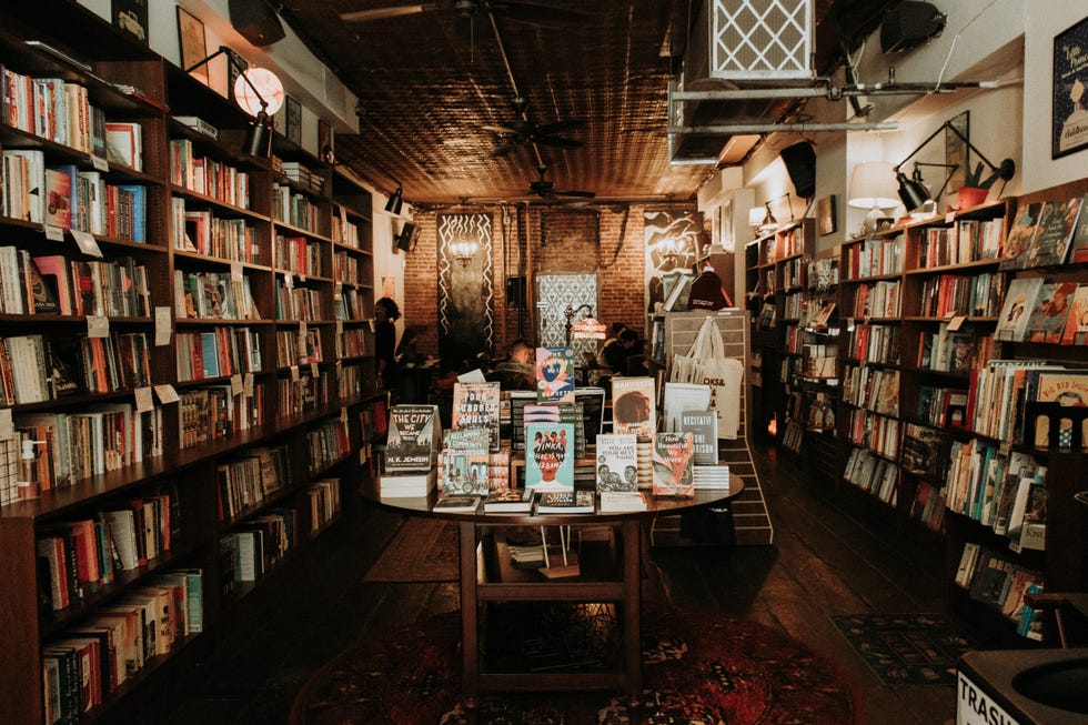 interior of a cozy bookstore with bookshelves and a central table displaying featured books