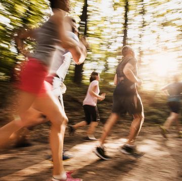 large group of people in blurred motion running a marathon in nature