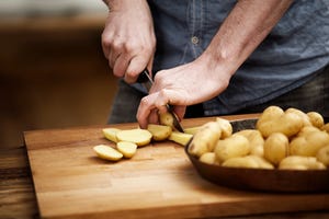 man cutting potatoes in kitchen