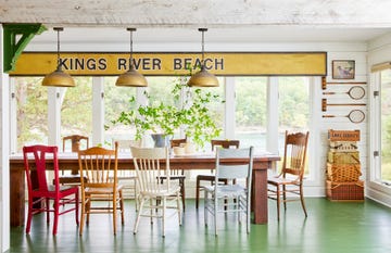 lake cabin dining room with green painted floors and mismatched chairs