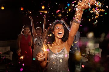 people celebrating on new years eve with sparklers and confetti