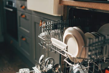 open dishwasher with clean utensils in it