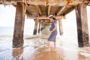 pregnant woman holding her belly on the beach