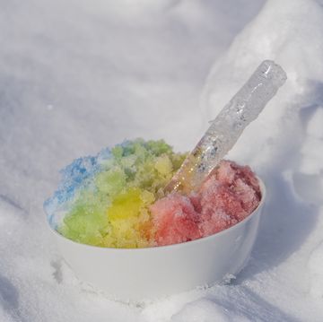 rainbow shaved ice in dessert bowl on white snow background, close up