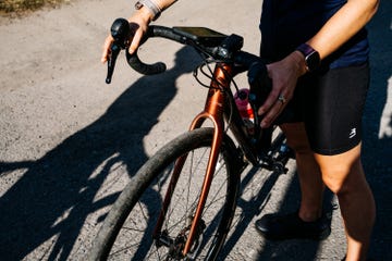 Bicyclist holding handlebars on gravel path