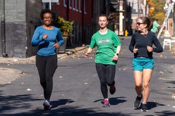 three women jogging on a street