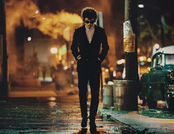 a lone figure walking in a dimly lit urban street at night