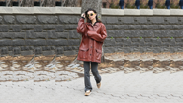 individual walking along a path with a stone wall in the background