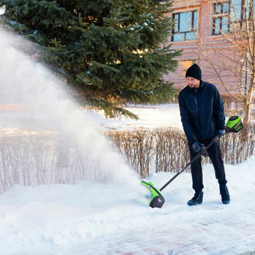 person using a snowblower to clear snow from a walkway