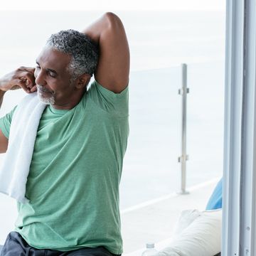 smiling mature man stretching in balcony