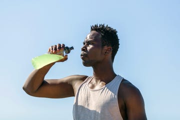 athlete drinking sports drink in water bottle