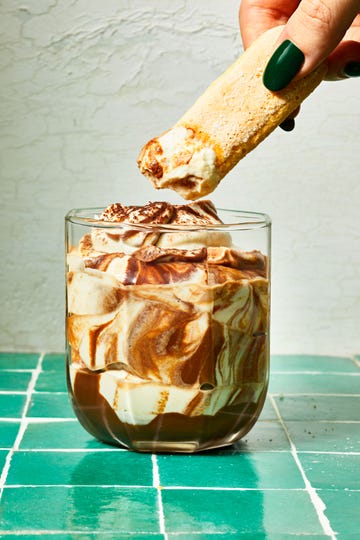 tiramisu dip in a glass on a green tile surface