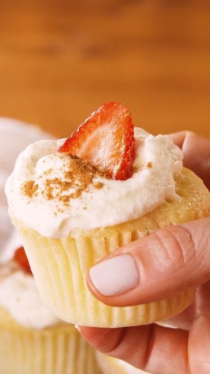 tres leches coconut cupcake with a slice of strawberry on top