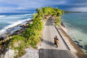 een scooter met twee mensen op eilandnatie tuvalu