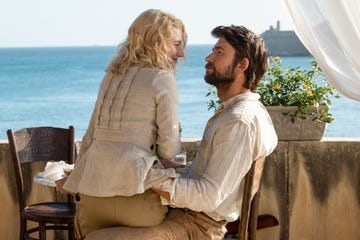 couple seated at a seaside table enjoying a meal