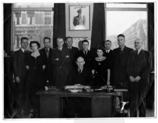 De mini-Gestapo van de Haarlemse politie begin 1944. Jan van Bragt was toen nog niet in vaste dienst. Derde van rechts Fake Krist. Na de oorlog werd op het portret van Adolf Hitler 'chauffeur'geschreven. Foto Nationaal Archief