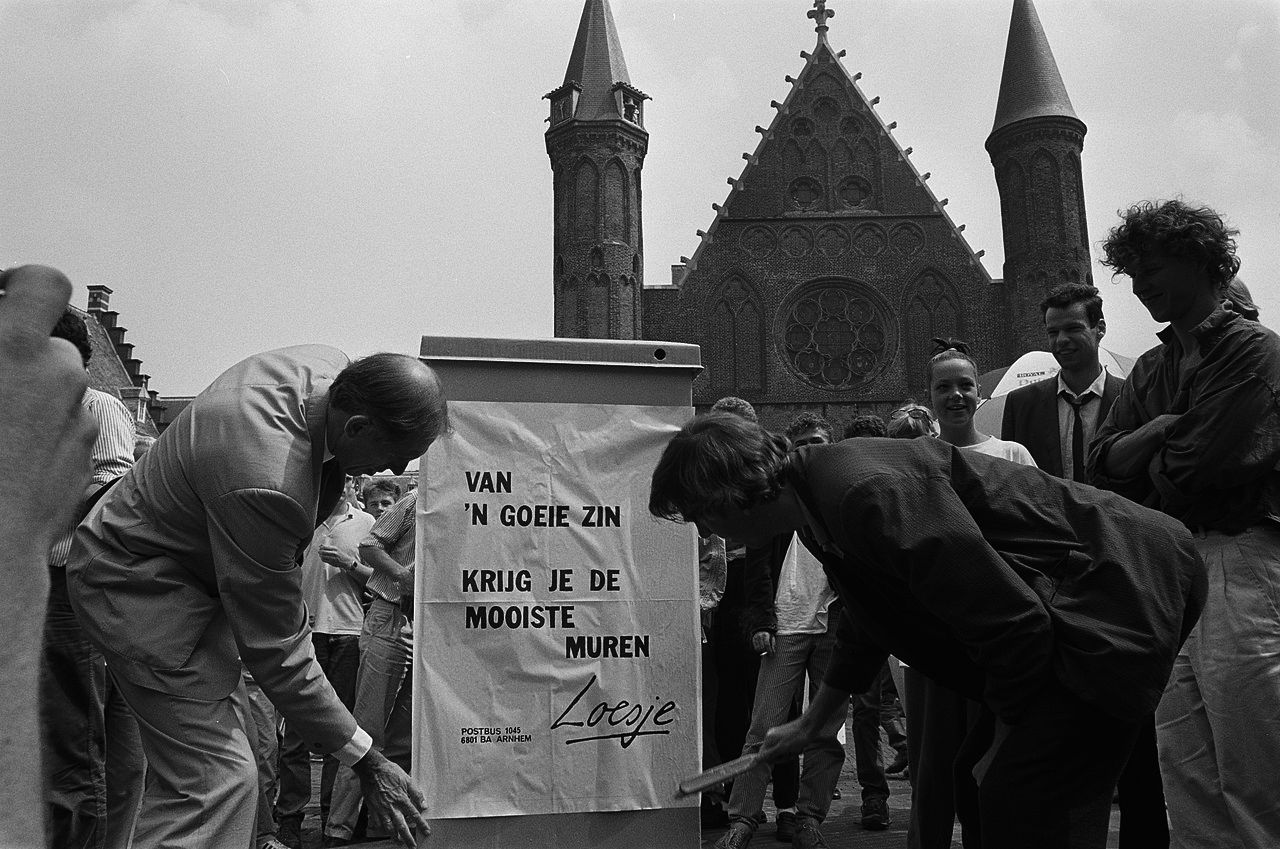 De Kamerleden Lankhorst (r) en Dijkstal plakken een Loesje-affiche op het Binnenhof, 30 juni 1988