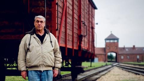 Gary Sokolov standing on the train tracks leading up to Auschwitz