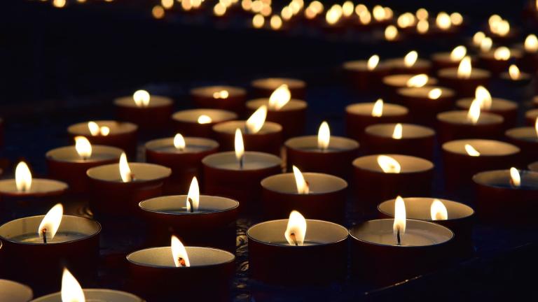 A collection of lit candles in the dark