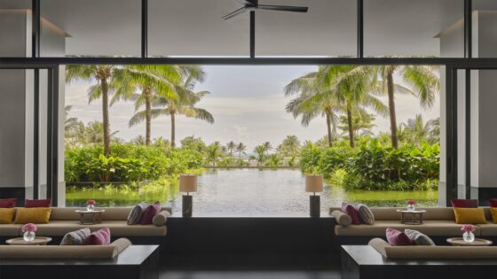 lounge in Regent Phu quoc with windows framing a view of palm trees and pool