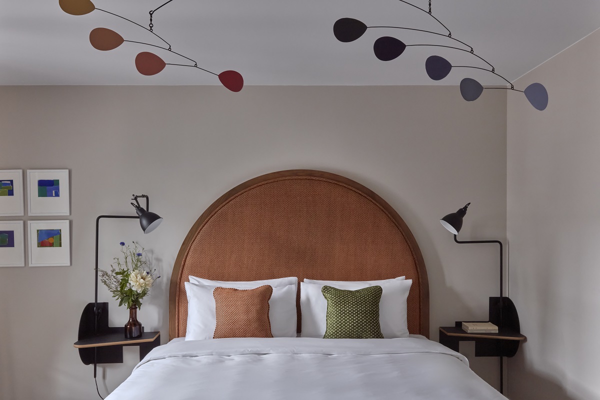 curated art and mobiles above the bed in the suite designed by gilbert Kann in Le Grand Hôtel Cayré