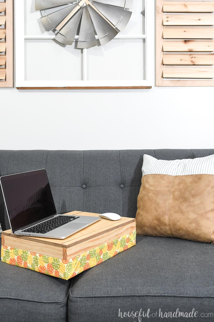 Homemade lap desk with storage on the couch with a laptop on it. 