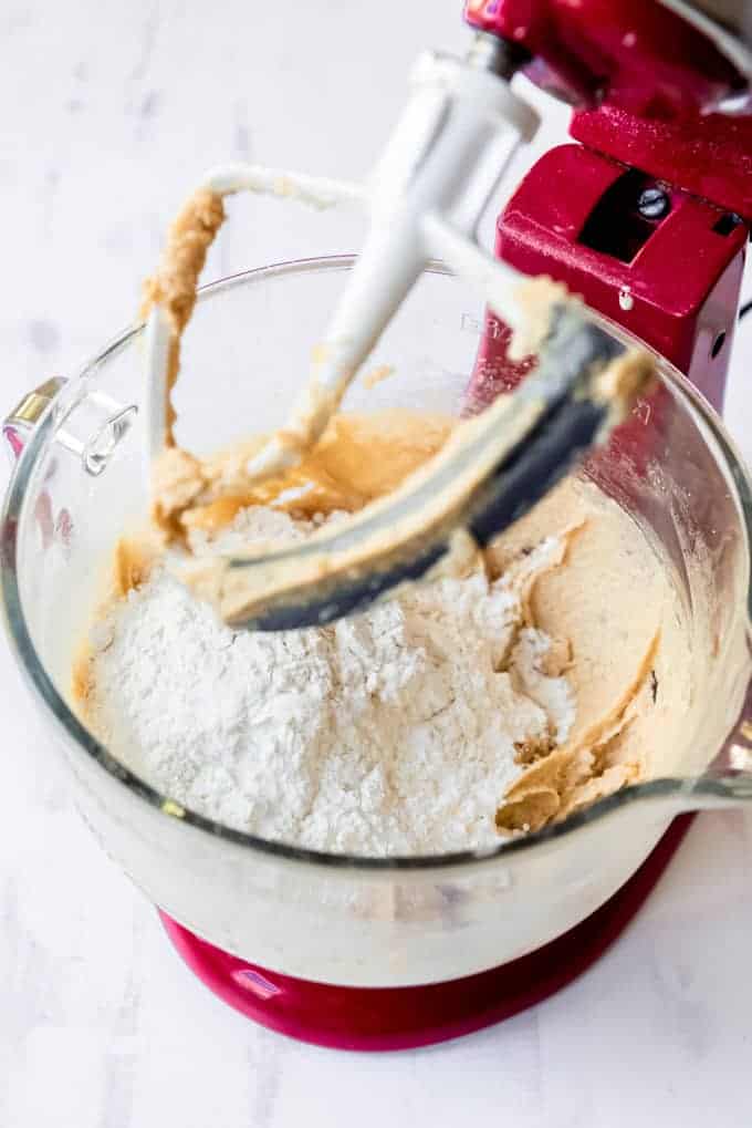 Adding flour and dry ingredients to the white chocolate cranberry cookie dough. 