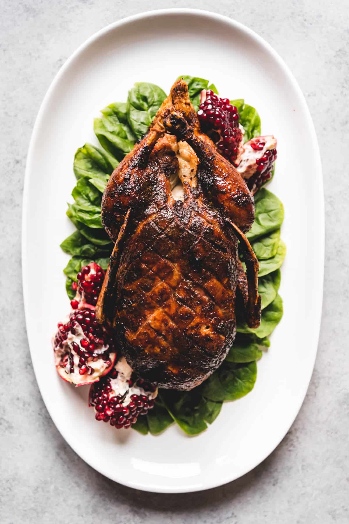 An image of a honey roast duck served whole on a platter.