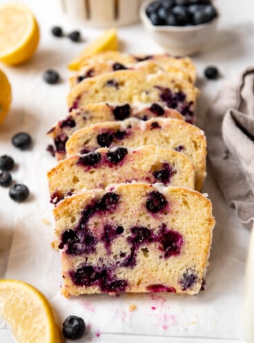 Slices of glazed lemon blueberry quick bread leaning against each other.