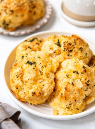 An image of cheddar bay biscuits piled on a plate.