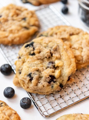 An image of blueberry muffin cookies on a wire cooling rack.